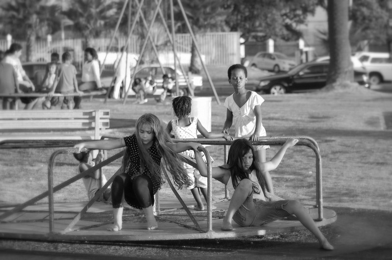 kids playing on a merry-go-round at sunset  on the promenade