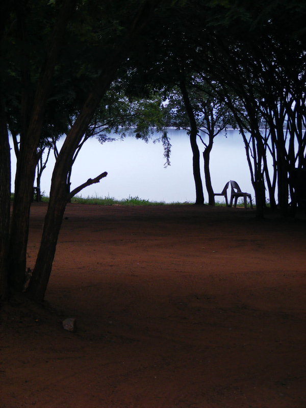Two chairs before a lake