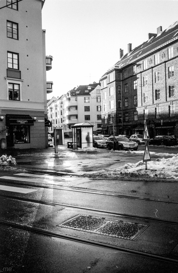 Gentleman waiting for something in an unused bus shelter on a sunny day